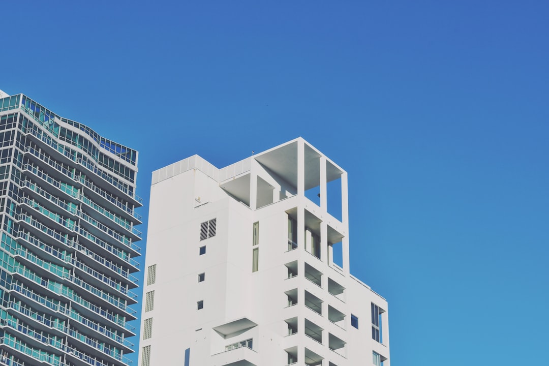 a tall white building sitting next to a tall white building, Art deco buildings in Miami