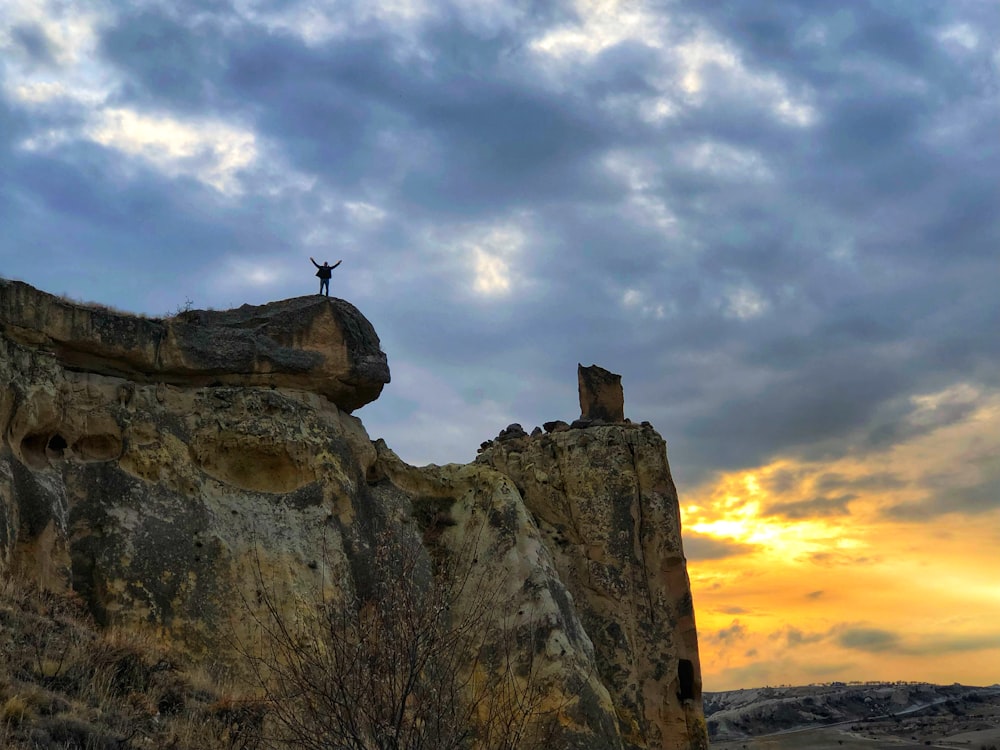 una persona in piedi sulla cima di una formazione rocciosa