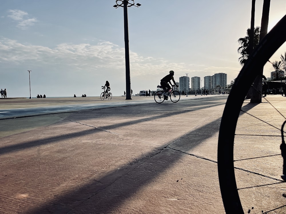 a man riding a bike down a street next to tall buildings