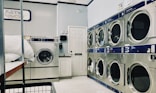 a row of washers and dryers in a laundry room