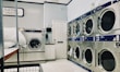 A robust, heavy-duty washing machine with a sturdy design in a bright laundry room.