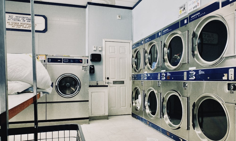 a row of washers and dryers in a laundry room