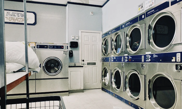 Commercial laundromat row of washing machines — commercial dryer vent cleaning in Los Angeles County