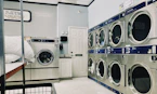 a row of washers and dryers in a laundry room