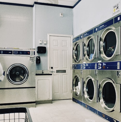 a row of washers and dryers in a laundry room