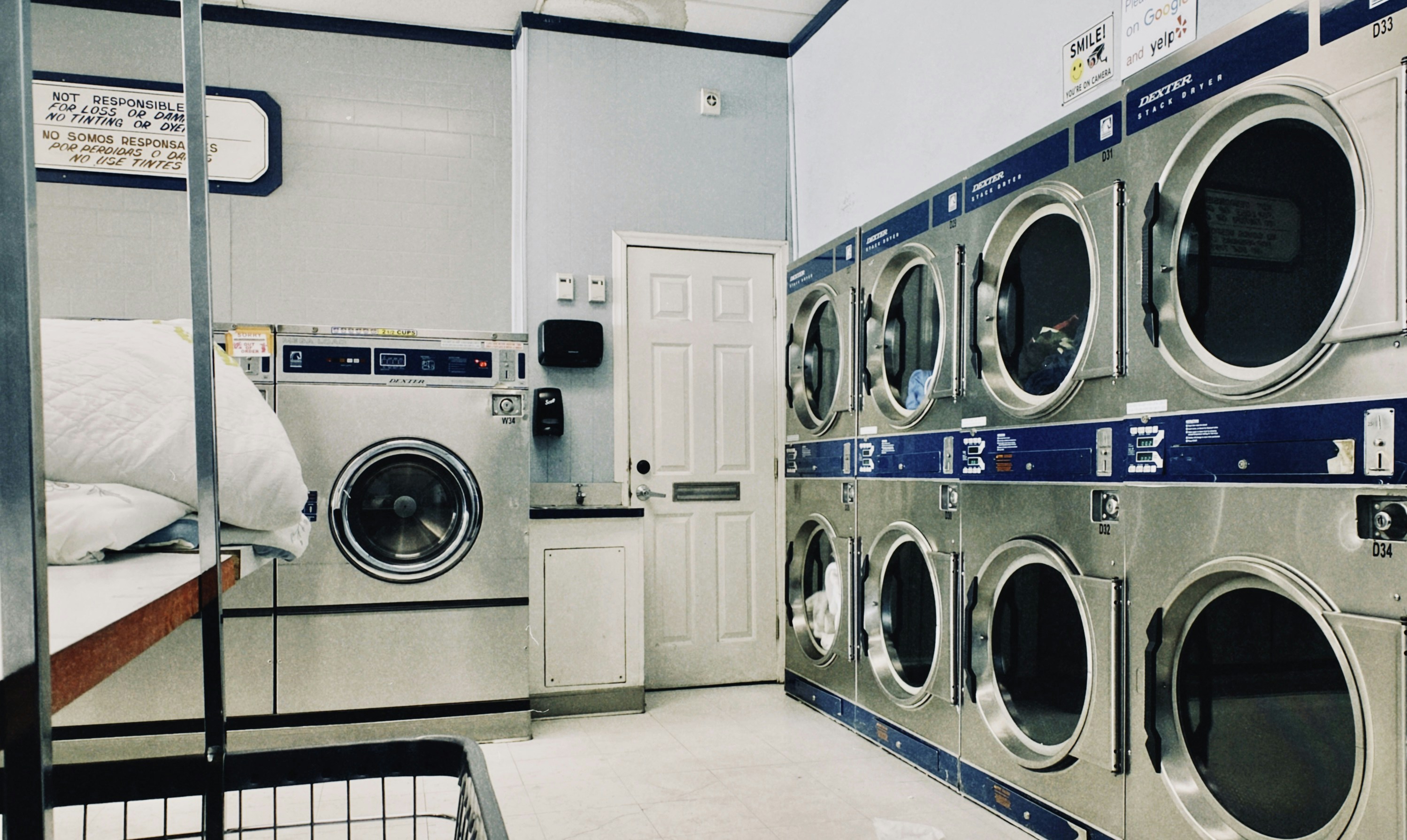 a row of washers and dryers in a laundry room