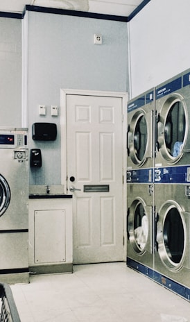 a row of washers and dryers in a laundry room