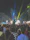 Crowd dancing energetically with colorful stage lighting at an outdoor night event