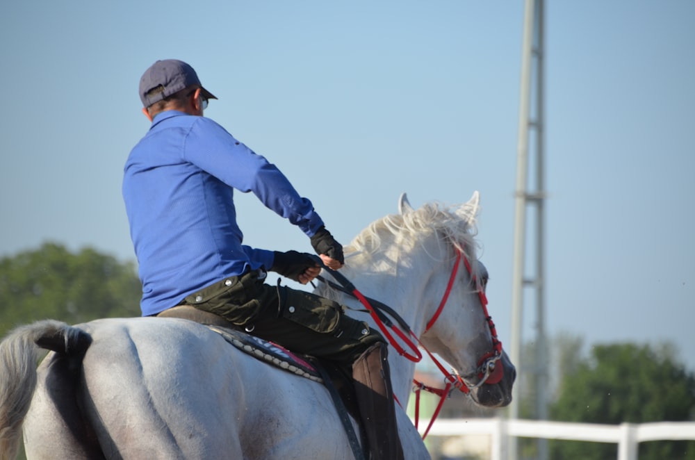 a man riding on the back of a white horse