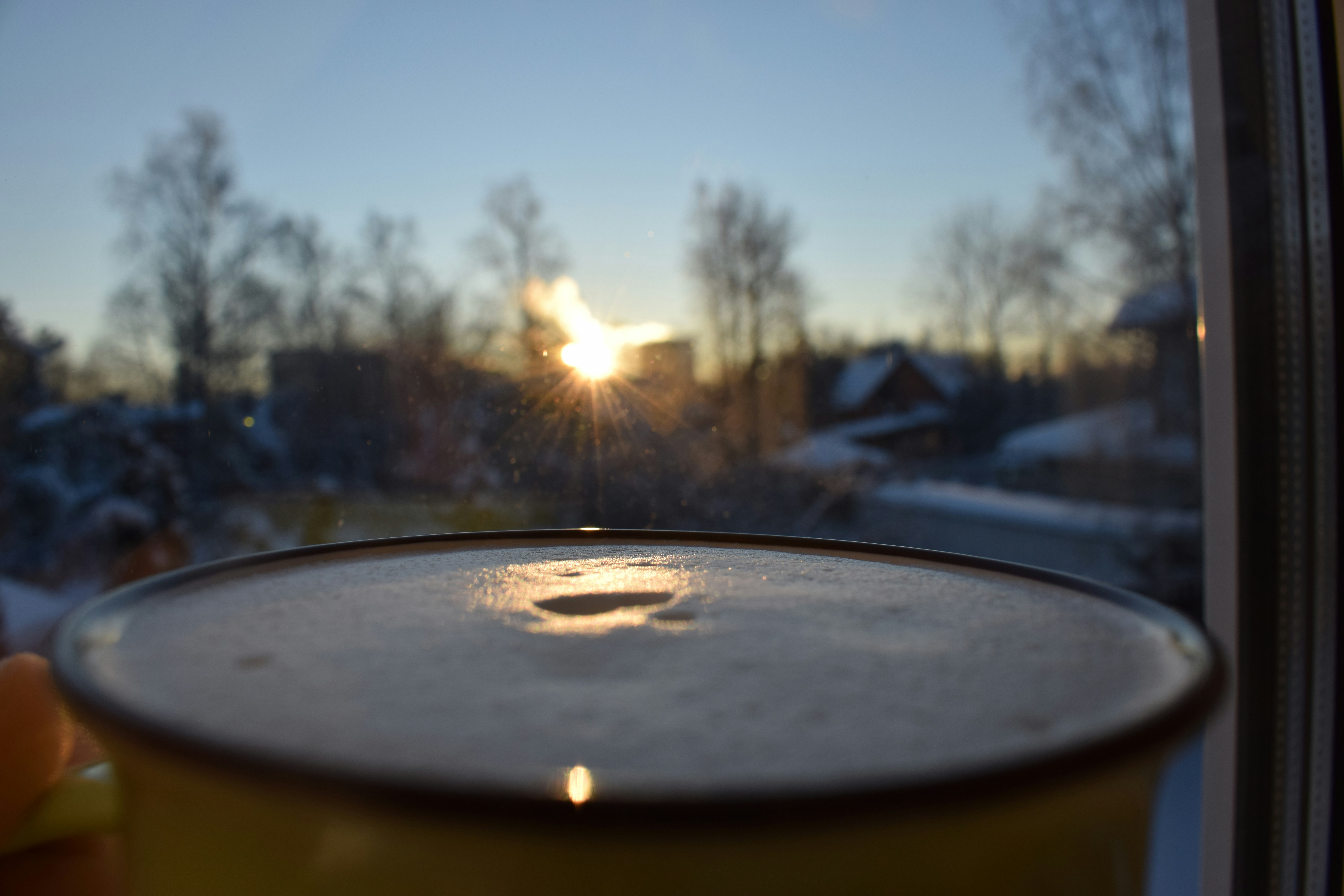 woman sitting peacefully by window with morning coffee