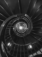 a black and white photo of a spiral staircase
