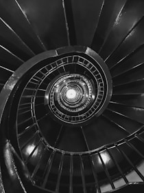 a black and white photo of a spiral staircase