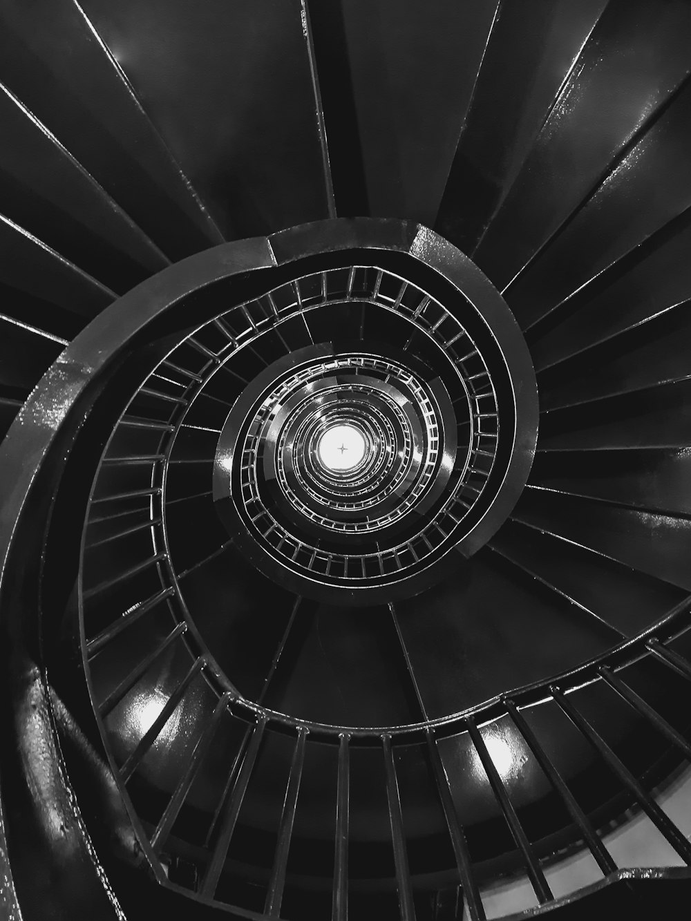 a black and white photo of a spiral staircase