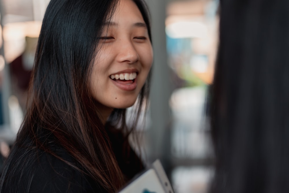 a woman smiles as she holds a folder