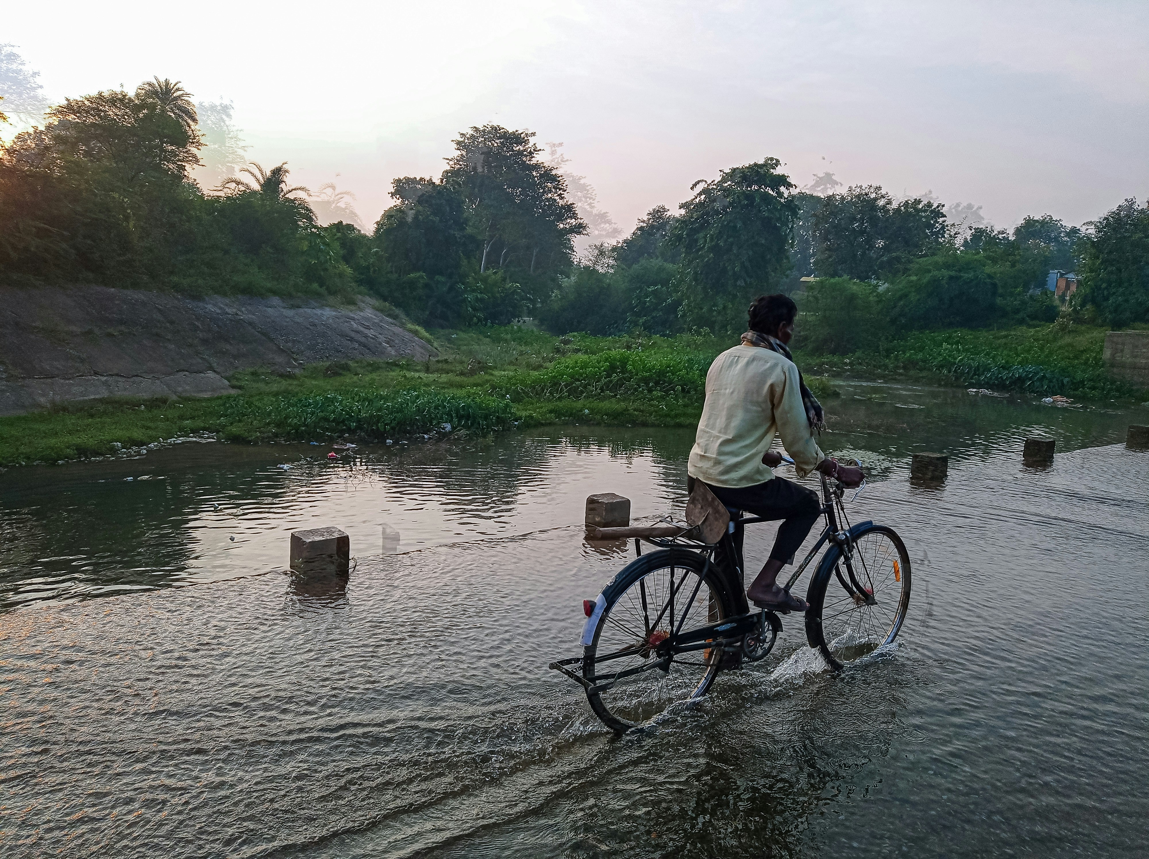 एक जल संरक्षण परियोजना में भाग ले रहे लोग, जैसे छोटे चेक डैम बनाना या पेड़ लगाना, उत्साह से काम कर रहे हैं।
