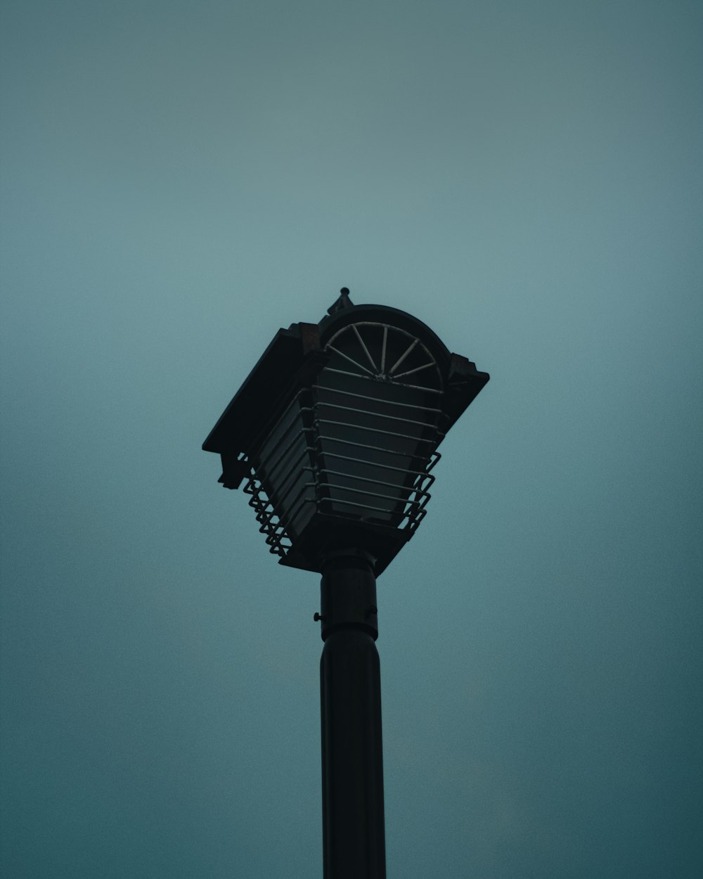 a clock on top of a pole with a sky background