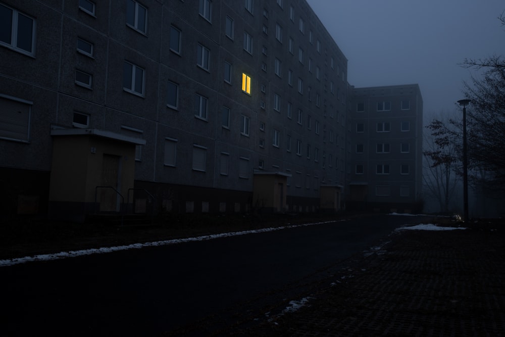a dark street with a building in the background