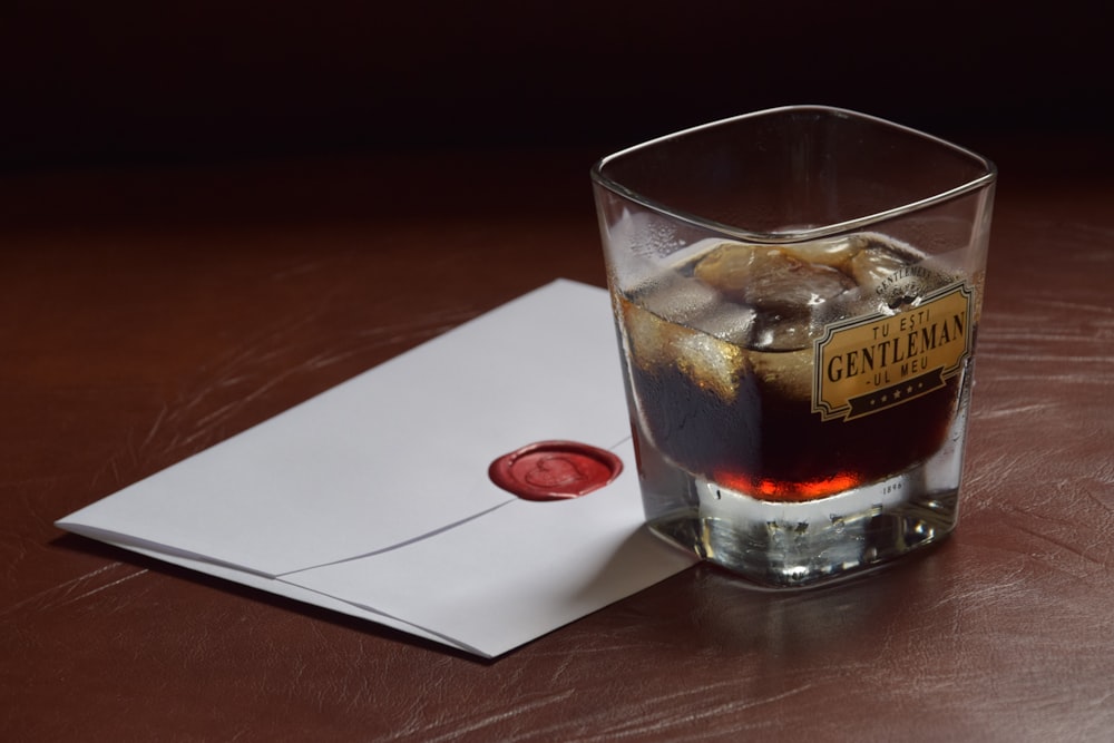 a glass of whiskey sitting on top of a wooden table