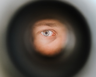 a man's eye is seen through a pipe