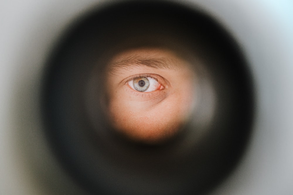 a man's eye is seen through a pipe