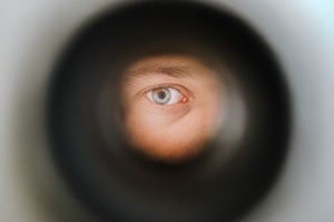 A green eye observing the outside world through a peephole in Berlin.