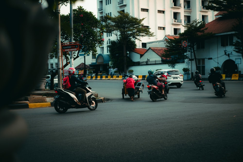 a group of people riding motorcycles down a street
