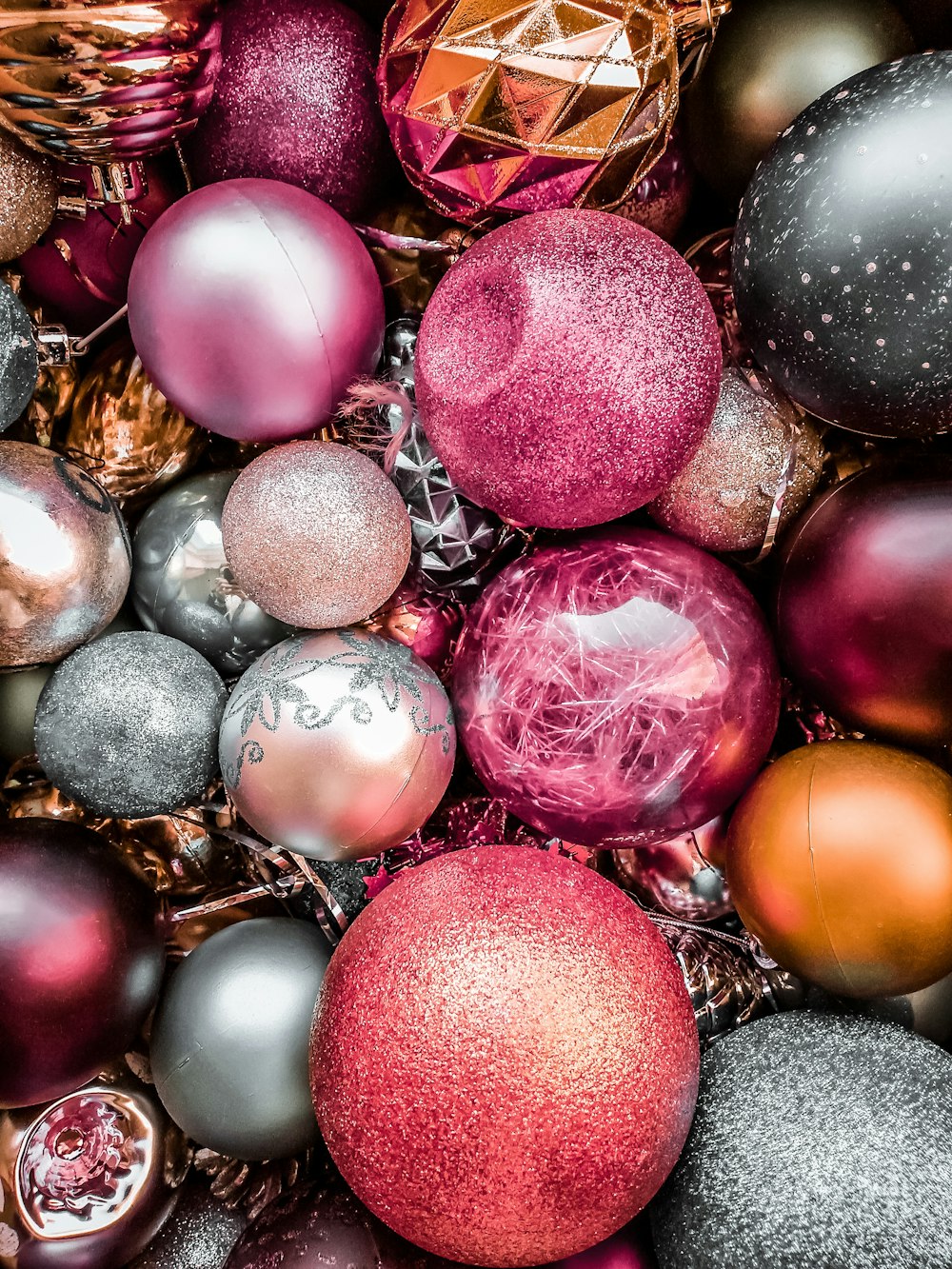 a pile of different colored christmas ornaments