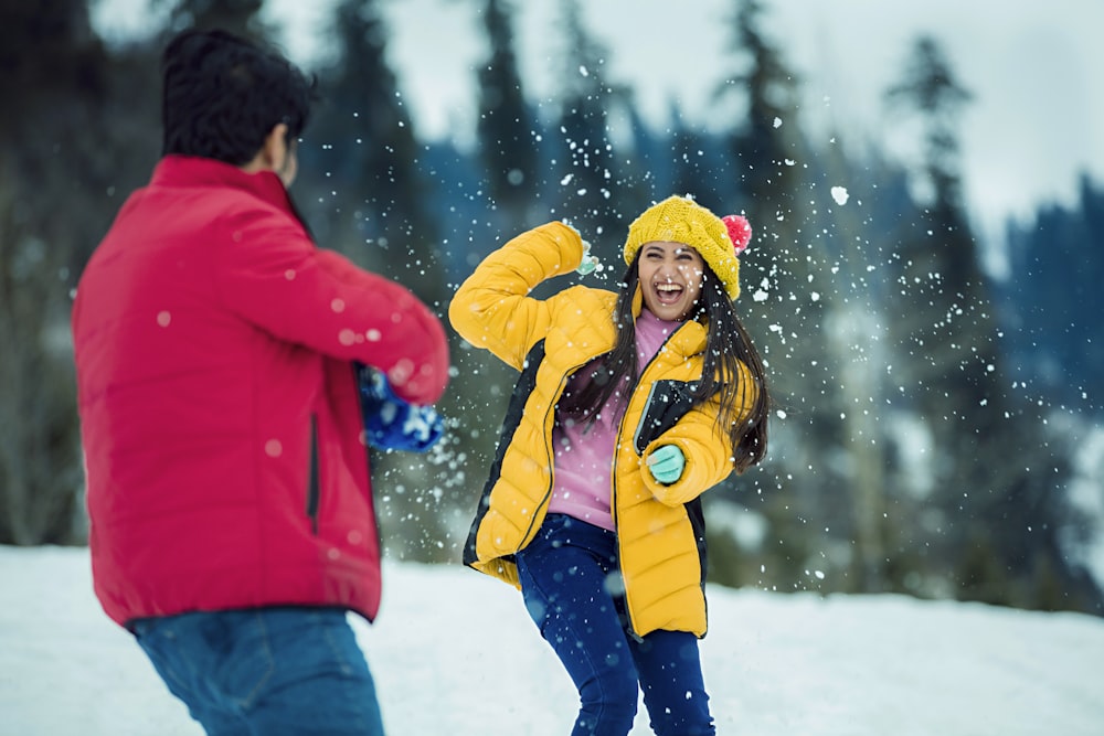 a man and a woman playing in the snow