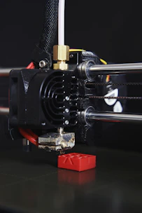 Close-up of a 3D printer nozzle creating a detailed plastic model layer by layer
