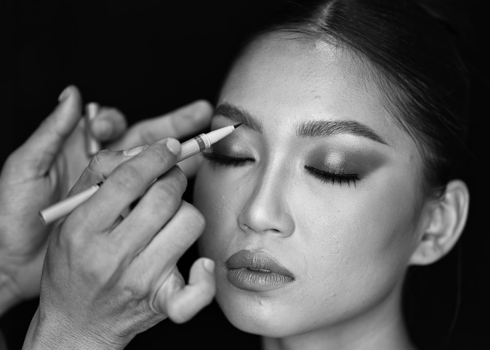 a woman is putting makeup on her face