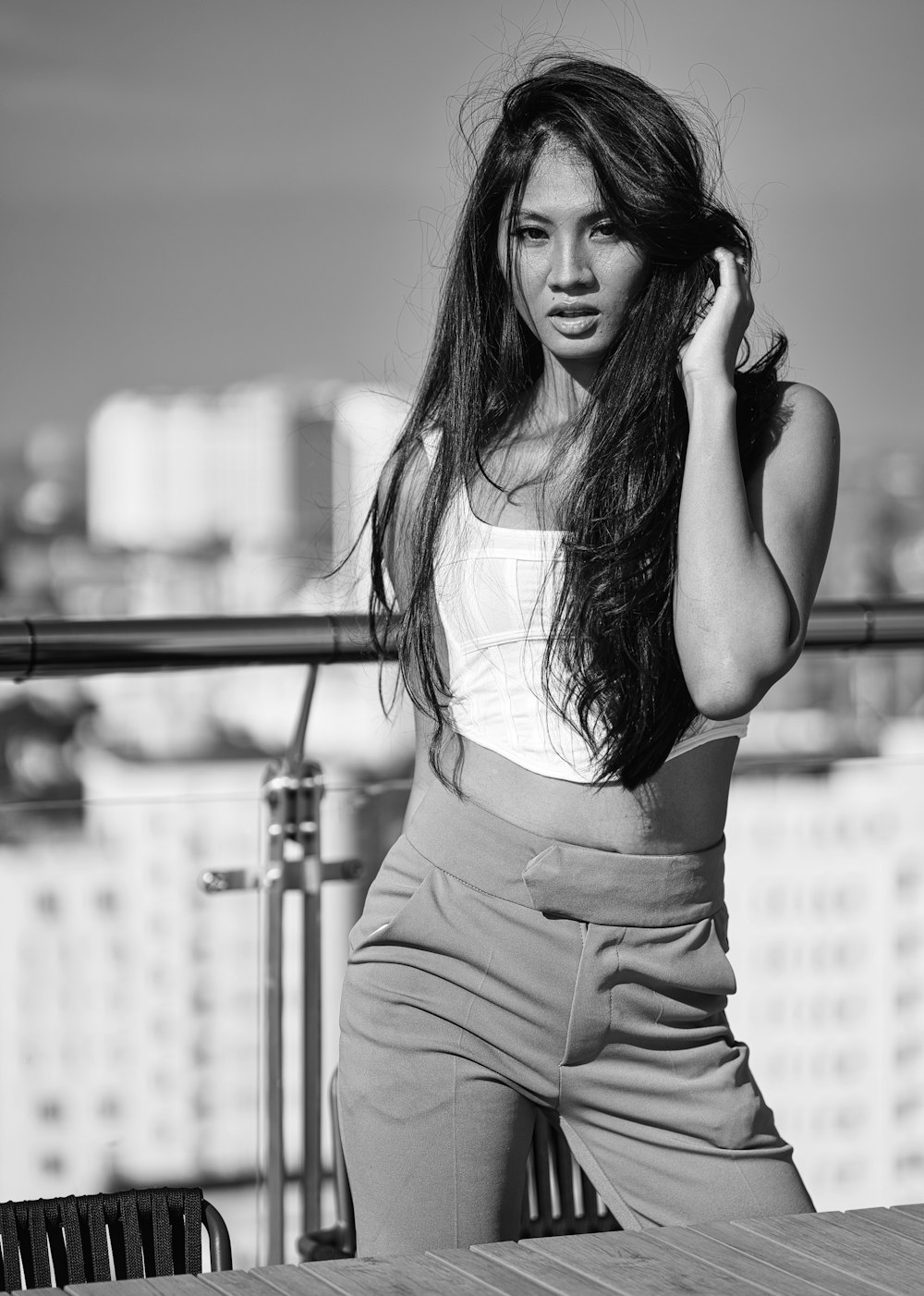 a woman standing on top of a balcony next to a table