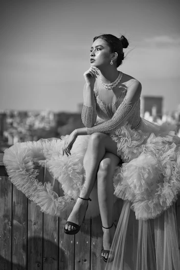 a woman sitting on top of a wooden fence