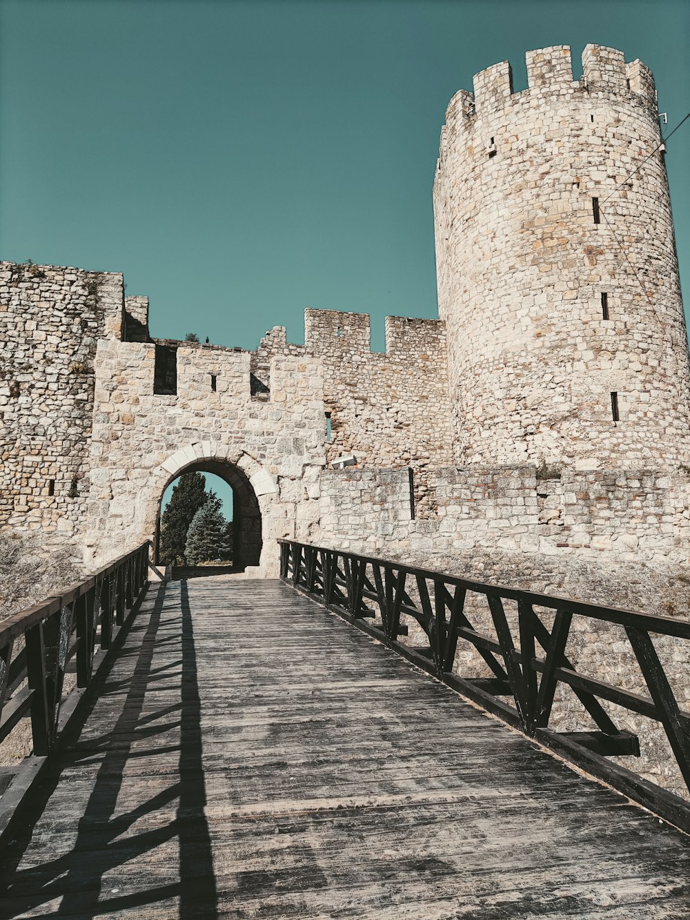 un pont en bois menant à un château en pierre