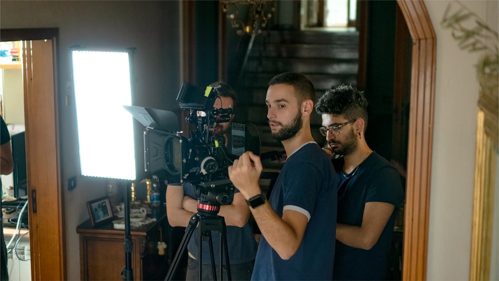 a man standing in front of a camera on a tripod