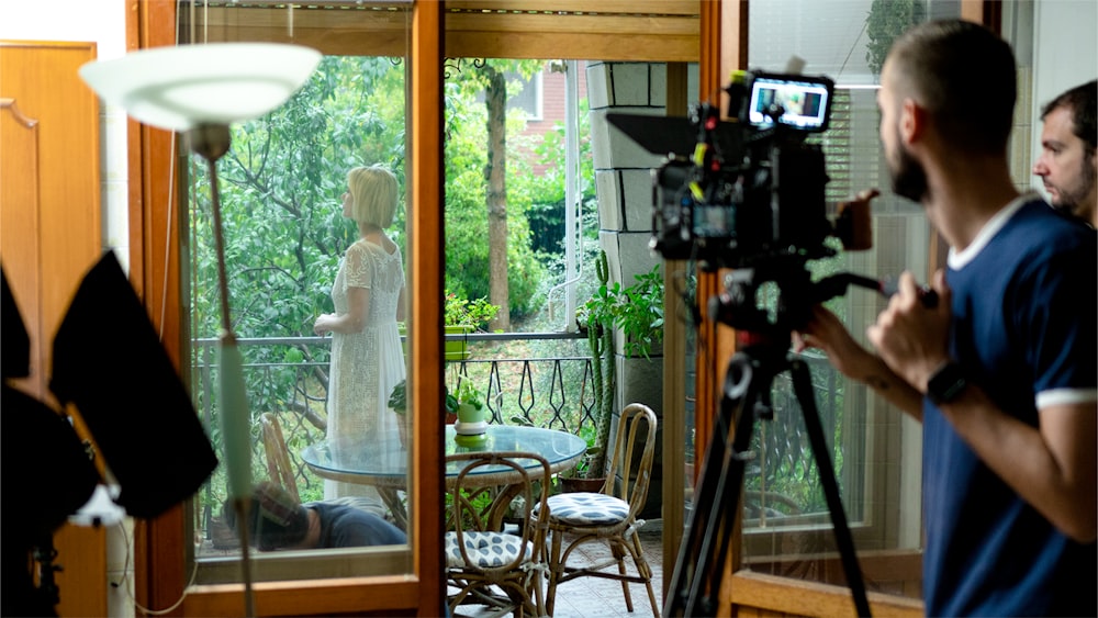 a man taking a picture of a woman in a white dress