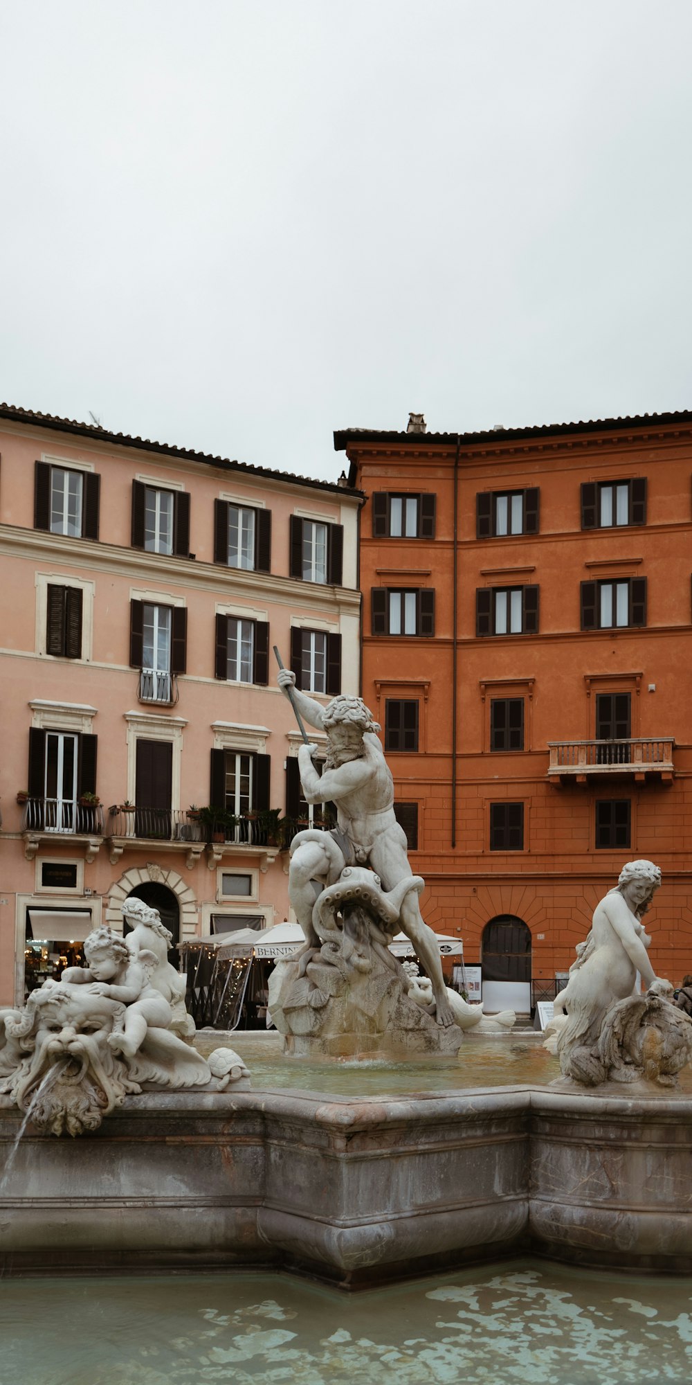 a fountain in front of a row of buildings