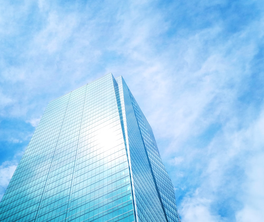 a very tall building sitting under a cloudy blue sky