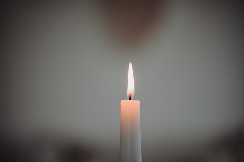a white candle with a single candle stick sticking out of it
