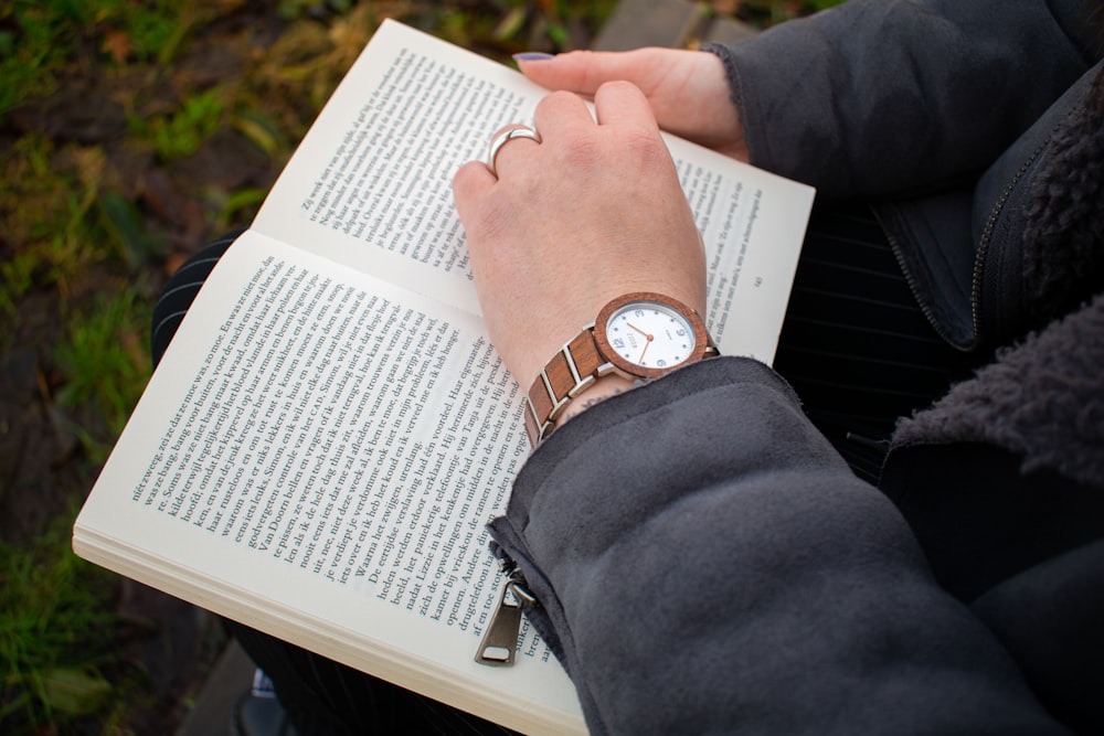 a person sitting on a bench reading a book