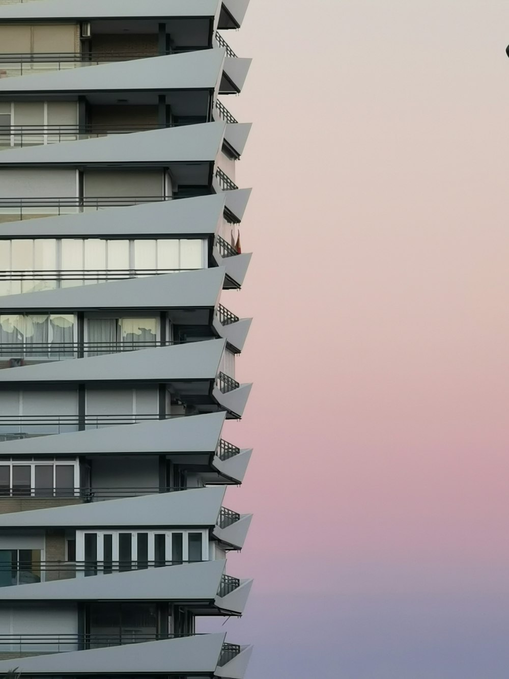 a tall building with balconies on the top of it