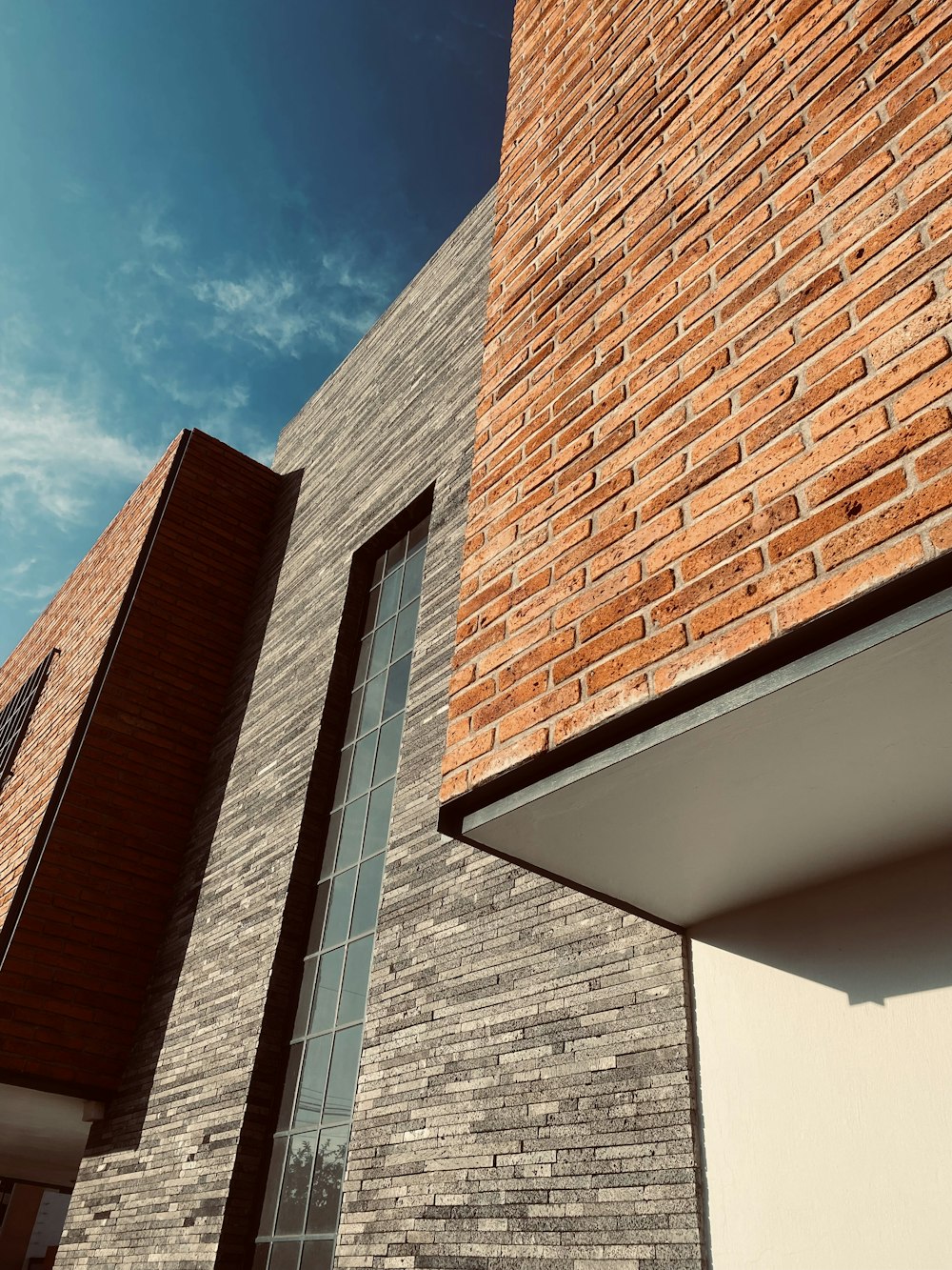 a tall brick building next to a tall window