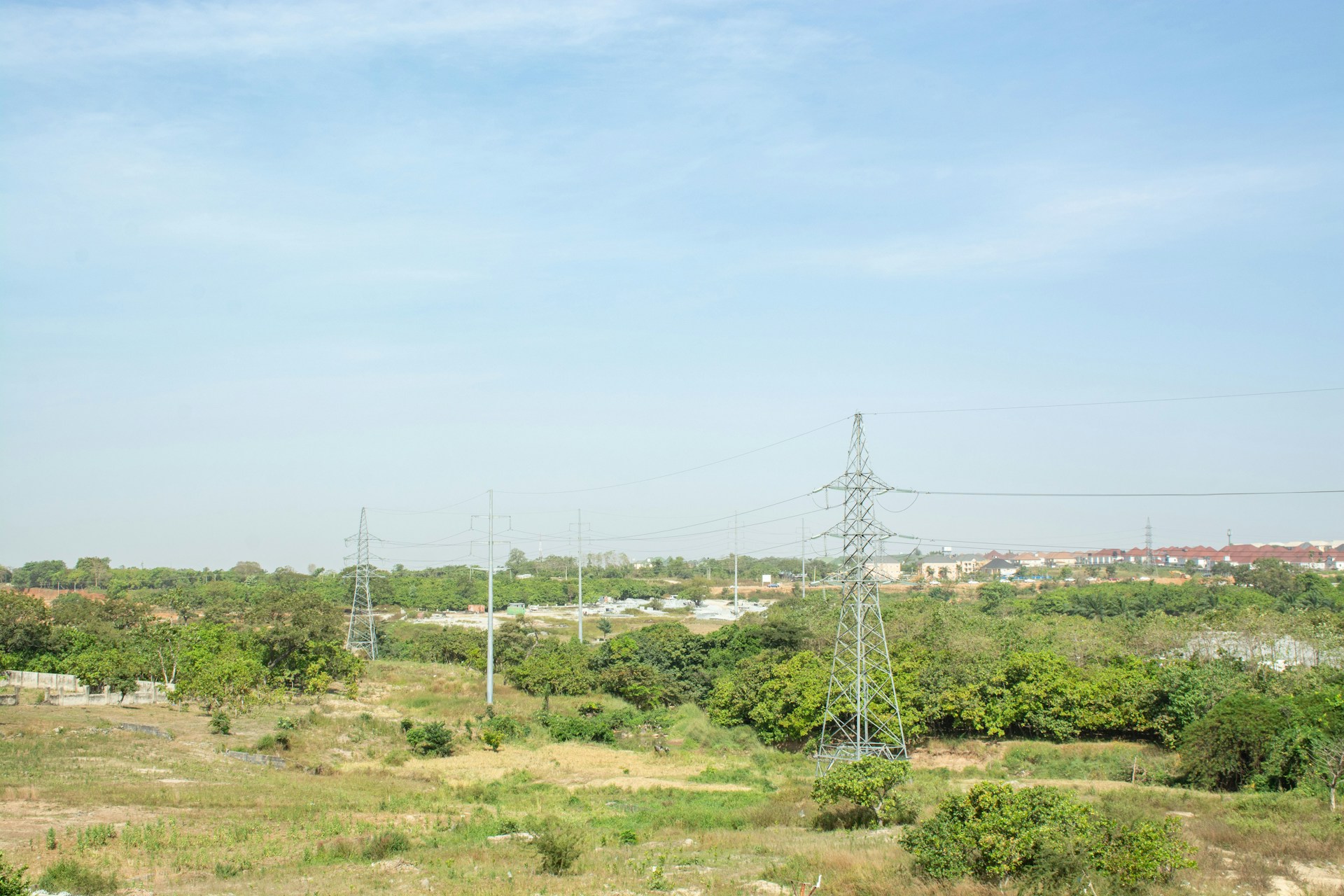 a grassy field with power lines in the distance