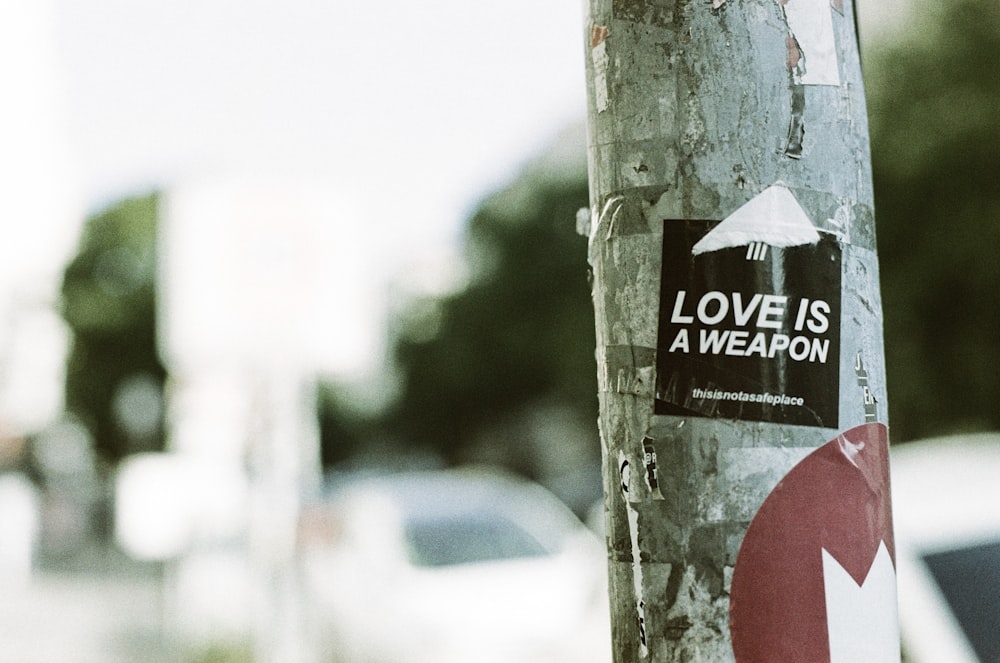 Una pegatina en un árbol que dice que el amor es un arma