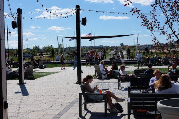 A candid shot of people enjoying a sunny outdoor festival with food stalls and live performances.