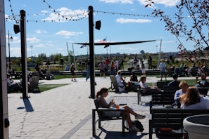 A lively crowd gathered around a decorated outdoor stage during a sunny local festival