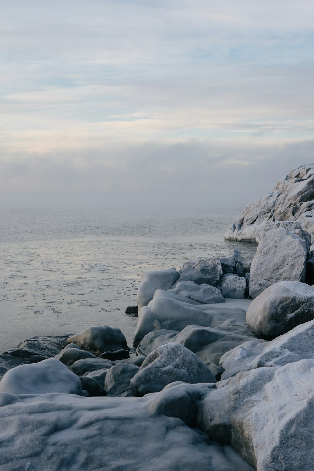a rocky shoreline covered in snow and ice