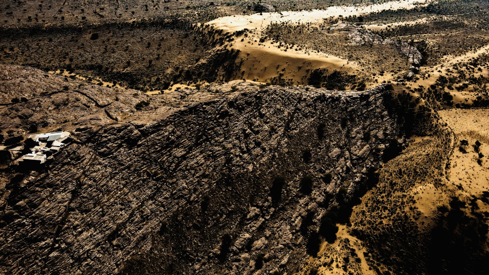 an aerial view of a dirt field with a dirt mountain in the background