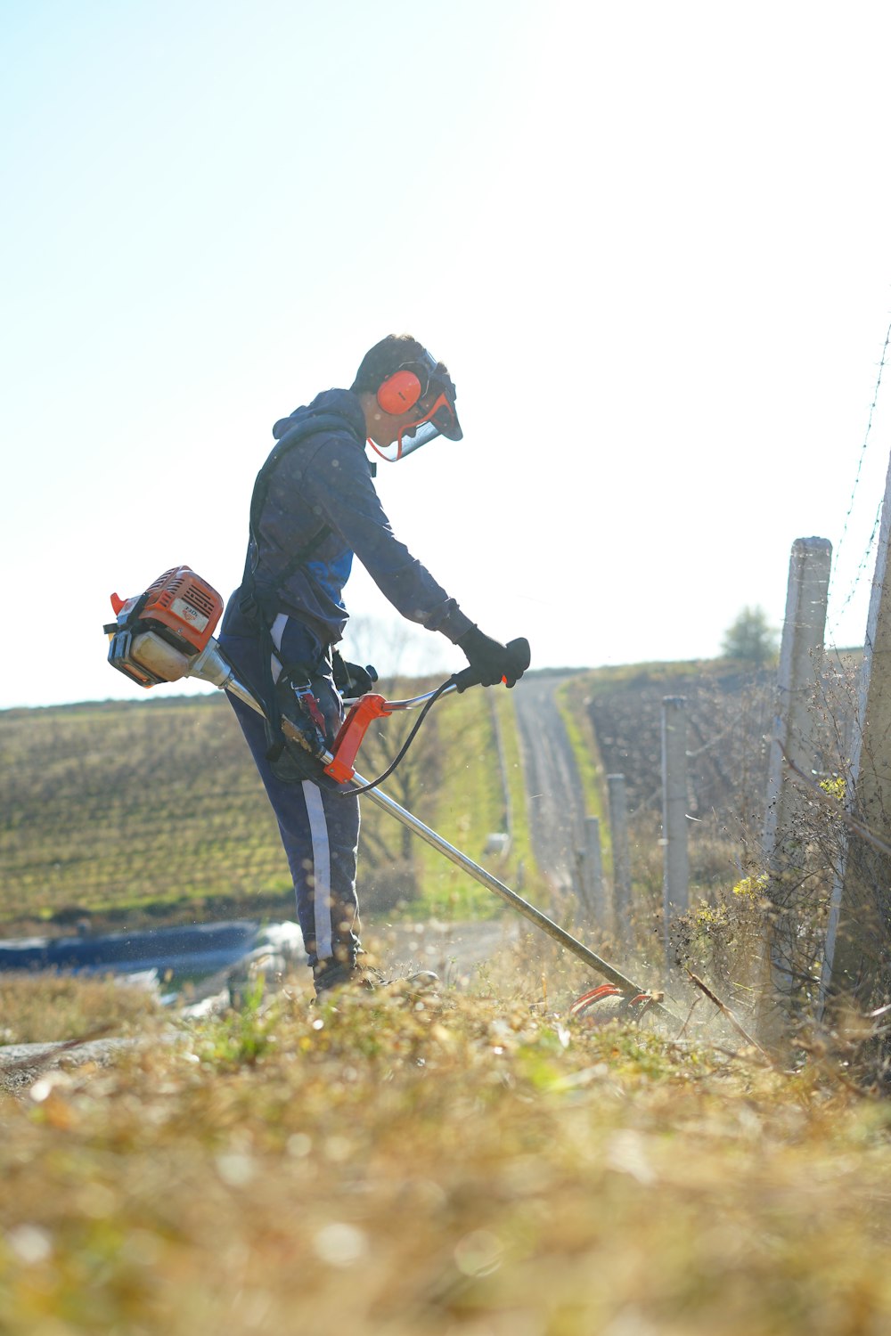 a man in a helmet is using a hedge trimmer