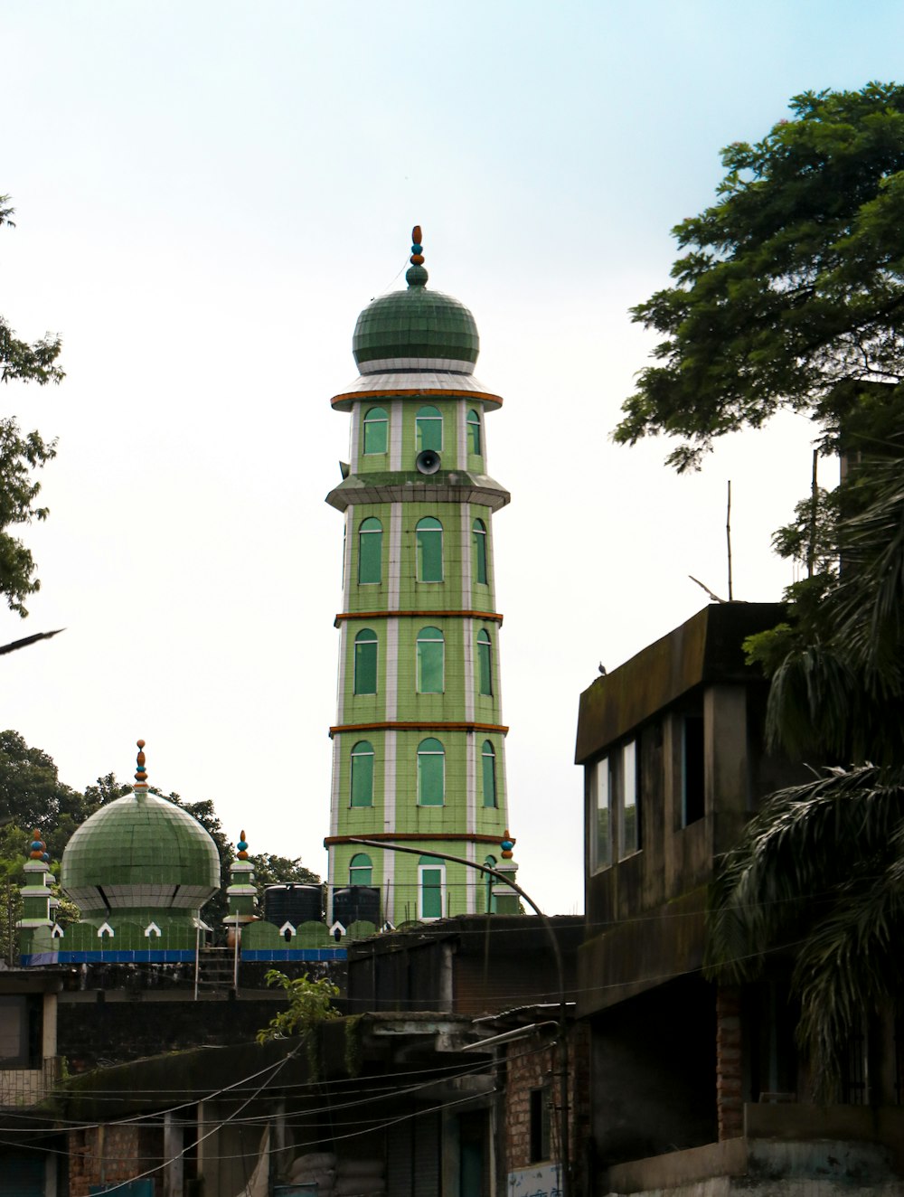 a tall green and white building with a green dome