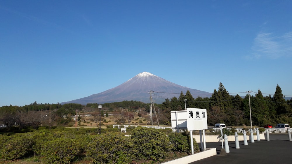 a mountain in the distance with a sign in front of it